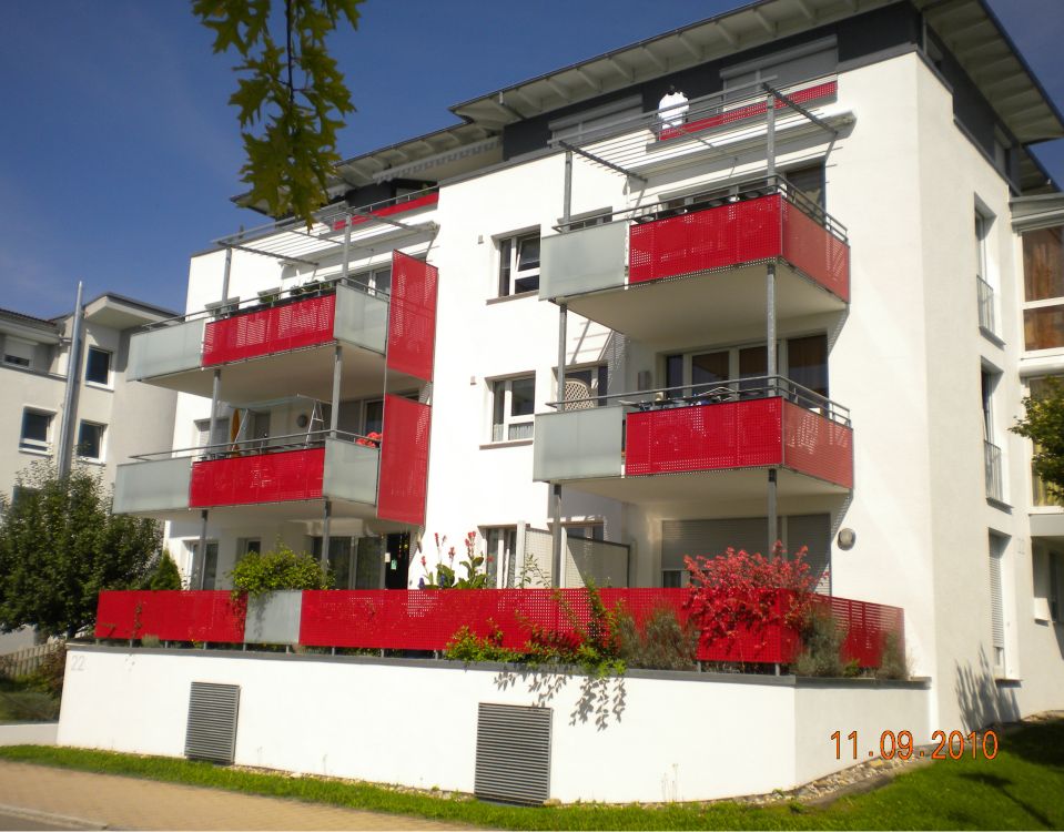 Hausfassade mit roten Balkonen